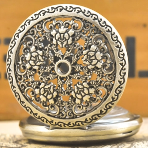 Macro shot of an antique bronze pocket watch with an intricate hollow floral pattern