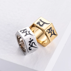 Macro shot of silver and gold stainless steel rings with hexagonal mantra engravings