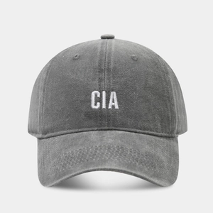 Close-up of CIA embroidery on dark gray washed denim baseball cap with vintage texture