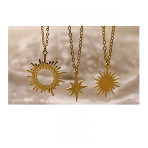 Detailed macro view of three 18K gold-plated stainless steel star and sun pendants