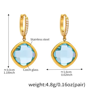 Détail de boucles d'oreilles en acier doré avec verre tchèque bleu clair et zircon