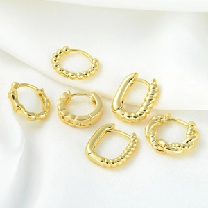 Classic gold geometric hoop earrings set on silk background including round and square styles