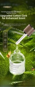 Detail of 160ml glass car aroma diffuser with wood lid against a green forest background