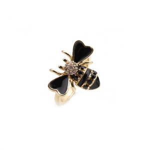 Detail of 18K gold bee ring with black enamel wings and sparkling zircon inlay