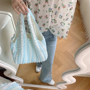 Detail view of blue and white striped bubble texture fabric on a stylish tote bag