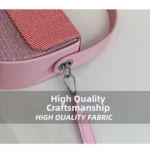 Detail of pink crossbody bag showing fabric flap and glitter side texture with silver hardware