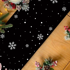 Festive Christmas table runner with white snowflakes on black background on wood table