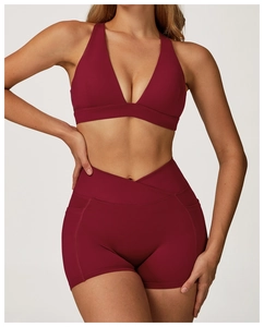 Detail of high-waisted yoga shorts featuring a criss-cross waistband and side pockets