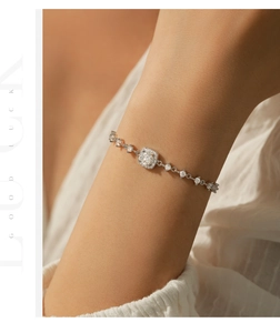Close-up of a silver geometric square moissanite bracelet on a woman's wrist