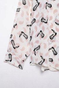 Detailed close-up of pink paisley and cowboy boot prints on a white vintage shirt