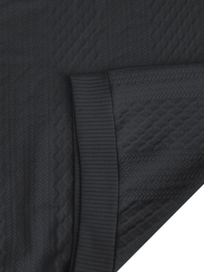 Detailed macro shot of dark grey jacquard waffle texture and ribbed cuff on hoodie