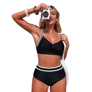 Two-piece black bikini with twist-knot bandeau top and white striped high-waisted bottoms