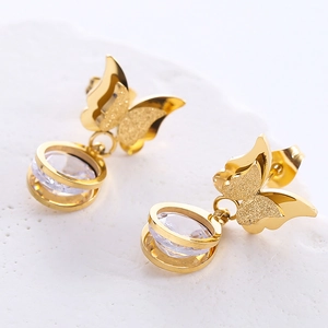 Elegant gold butterfly earrings with sparkling zircon drop on a white stone background