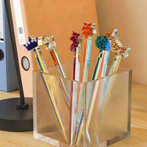 Schillernde Acrylstifte mit Kronen- und Hasenmotiven in einem Glasstifthalter