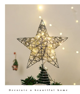 Close-up of silver hollow iron Christmas tree topper with warm glowing LED lights