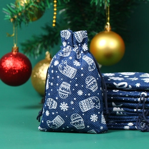 Detail der dunkelblauen Weihnachtsgeschenktüte mit weißen Handschuhen und Schneeflocken
