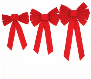 Detailed close-up of three red velvet Christmas bows for holiday party decorations