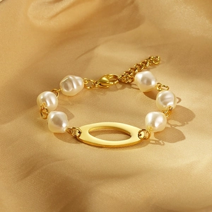 Detail of vintage gold-plated bracelet featuring baroque pearls and oval hollow charm