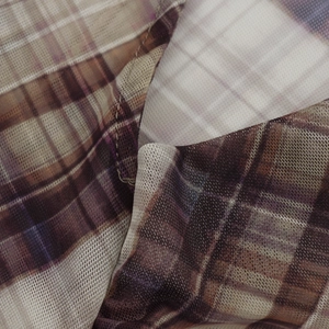 Detail of sheer mesh fabric featuring purple and brown plaid pattern and fine stitching
