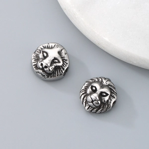 Detailed close-up of two stainless steel lion head beads for DIY jewelry making