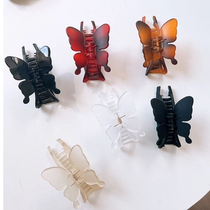 Set of six colorful butterfly hair claws in various finishes on a white background