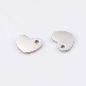 Macro view of two polished stainless steel heart charms with pre-drilled holes