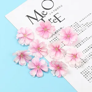 Close-up of ten realistic pink silk plum blossom flower heads for DIY crafts and decor