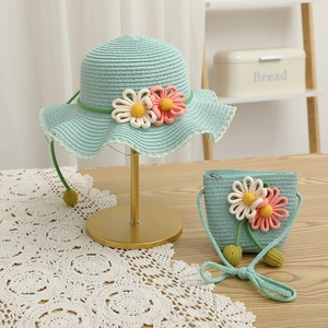 Close-up of mint green straw sun hat and matching bag with crochet sunflower details