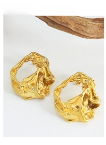 Detailed view of golden irregular textured earrings with organic lava-like pattern