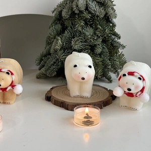 Polar bear scented candles with striped scarves on wooden tray for Christmas decor