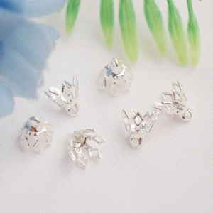 Set of six silver hollow crown bead caps for DIY jewelry making on white background