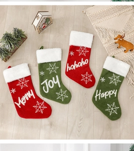 Close-up of four plush Christmas stockings with festive snowflake patterns and holiday text