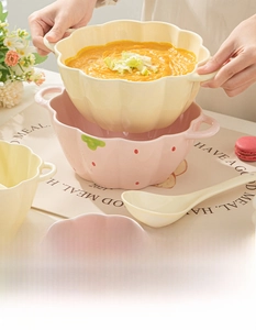 Detail of strawberry ceramic bowl with petal edges and dual handles for hot soup