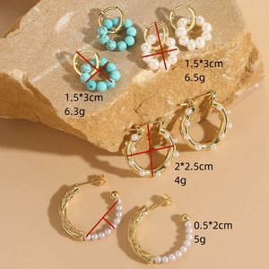 Bohemian gold-plated earrings with freshwater pearls and turquoise on natural stone background