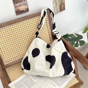 Detail of corduroy cow print tote bag showing thick texture and adjustable strap