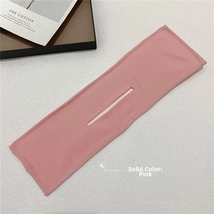 Detailed view of pink fabric hair bun maker tool laid on a white textured surface