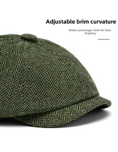 Close-up of green herringbone newsboy cap featuring wide foldable brim and wool texture
