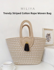 Detail of striped cotton rope woven tote bag with black tassel charm in cozy setting