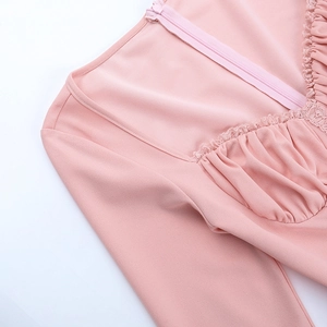 Detailed view of pink V-neck dress featuring lace trim and subtle pleated fabric textures