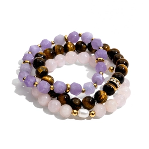 Detail of stacked amethyst and tiger eye stone beads with a white pearl accent