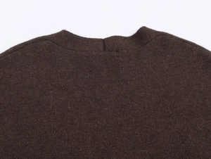 Dettaglio del colletto in maglia marrone scuro con cuciture rifinite e trama premium