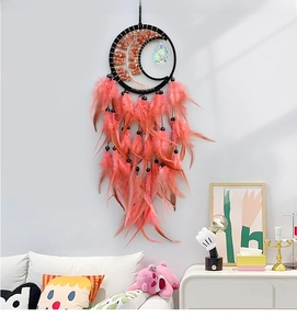 Detail of moon-shaped dream catcher with pink feathers and natural agate stone accents