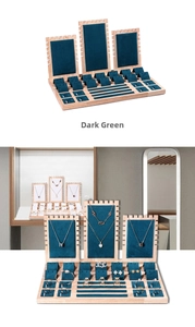 Dark green velvet and wood jewelry display set for necklaces and rings in a store showcase