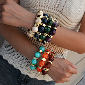 Close-up of bohemian chunky acrylic bead bracelets with golden metal spacers on a wrist
