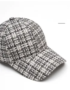 Close-up of black and white tweed baseball cap showing premium woven fabric texture