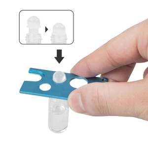 Blue essential oil bottle opener removing a roller ball on a clear glass bottle