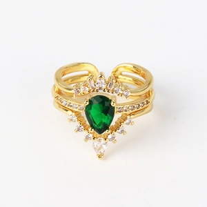 Detail of gold crown ring set with emerald drop gemstone and white zircon accents