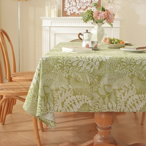 Close-up of cotton linen tablecloth with white leaf pattern on a green background
