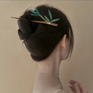 Épingle à cheveux chinoise en bois avec feuilles de bambou vertes sur un chignon élégant