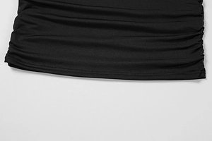 Detail of elegant black dress showing gathered ruching texture and double needle hemline